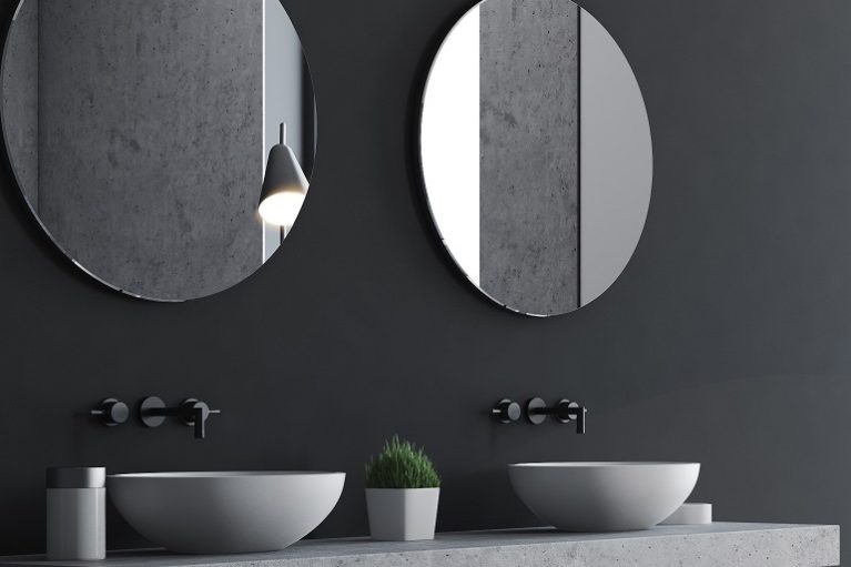 Gray bathroom interior with a concrete floor, a bathtub, a double sink with round mirrors and a framed poster on the wall. Side view. 3d rendering mock up